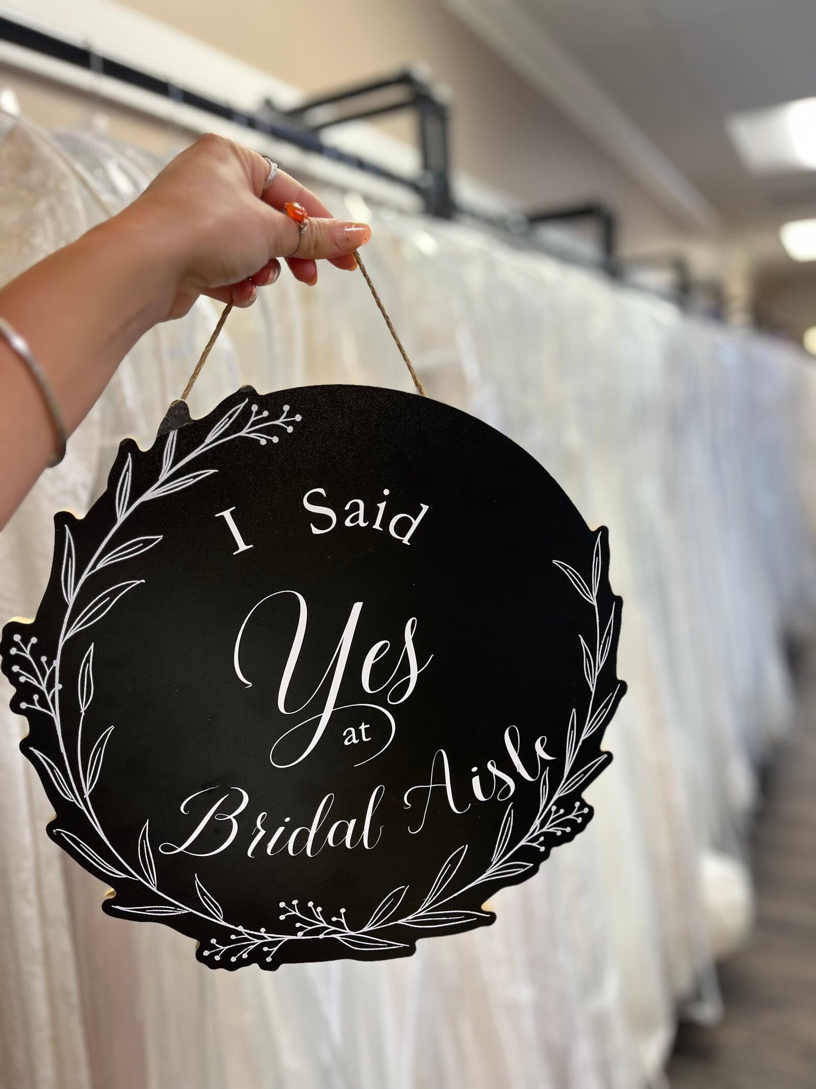 Bride holding 'I Said Yes at Bridal Aisle' sign — buy your wedding dress in Minnesota today