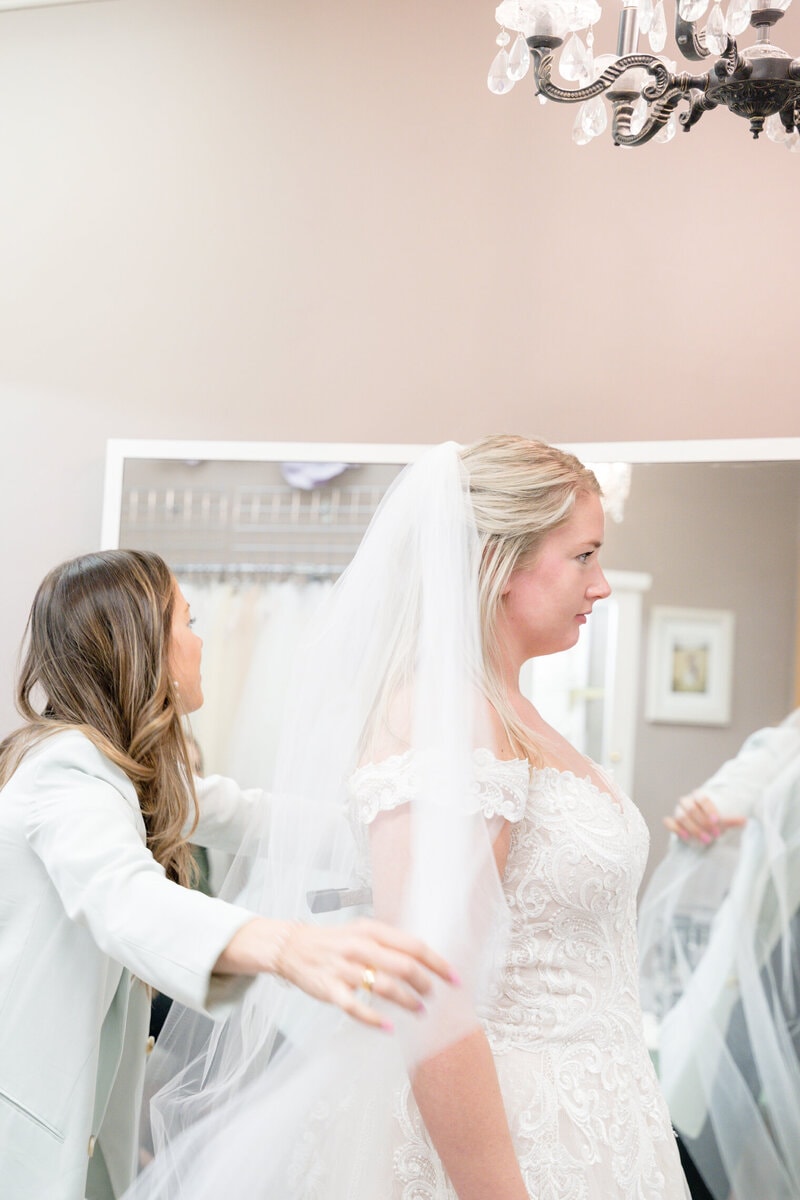 Bride trying on designer wedding gown during bridal appointment at Bridal Aisle Boutique, Osseo MN