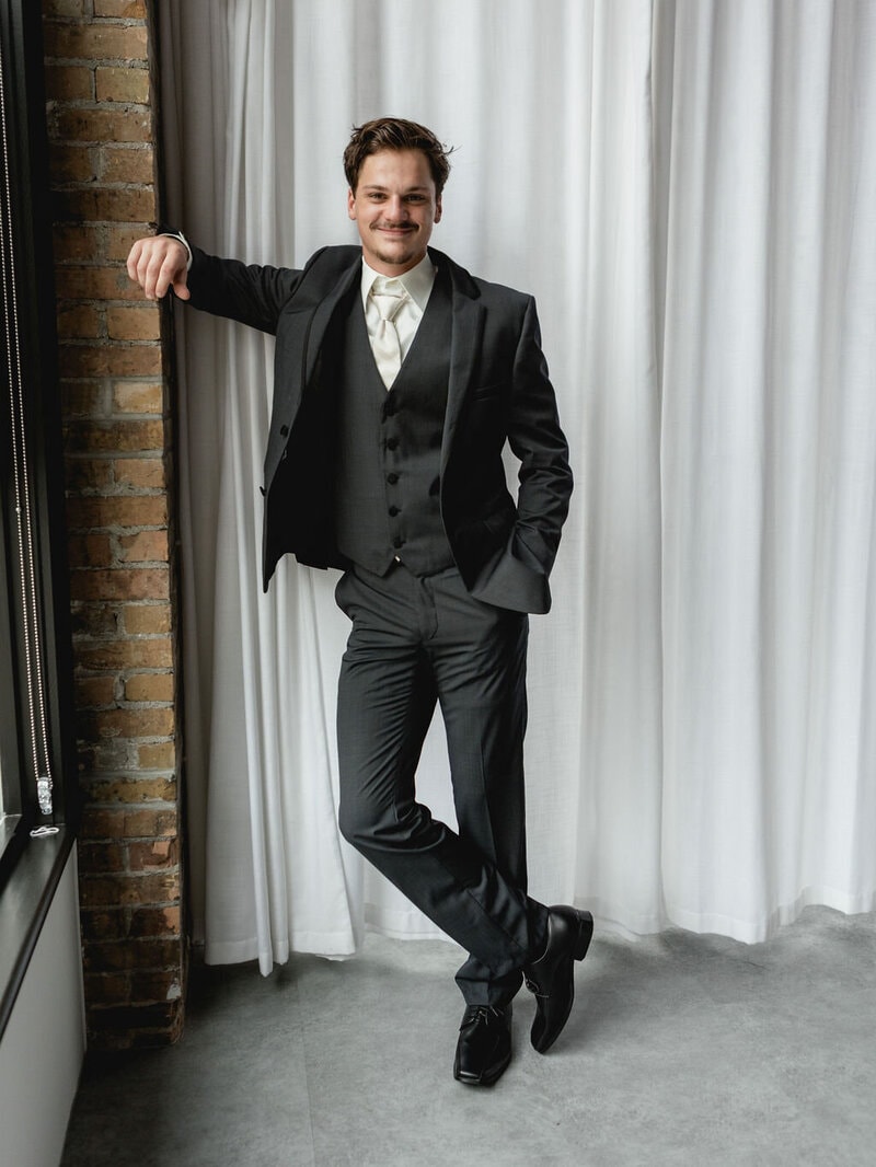 Groom selecting men's formal attire for wedding at Bridal Aisle Boutique — wedding suits Minnesota