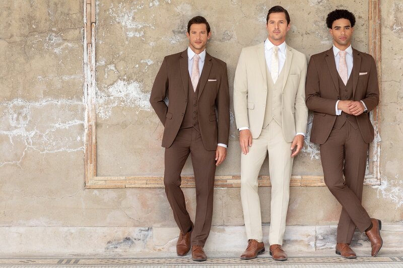 Groom selecting men's formal attire for wedding at Bridal Aisle Boutique — wedding suits Minnesota